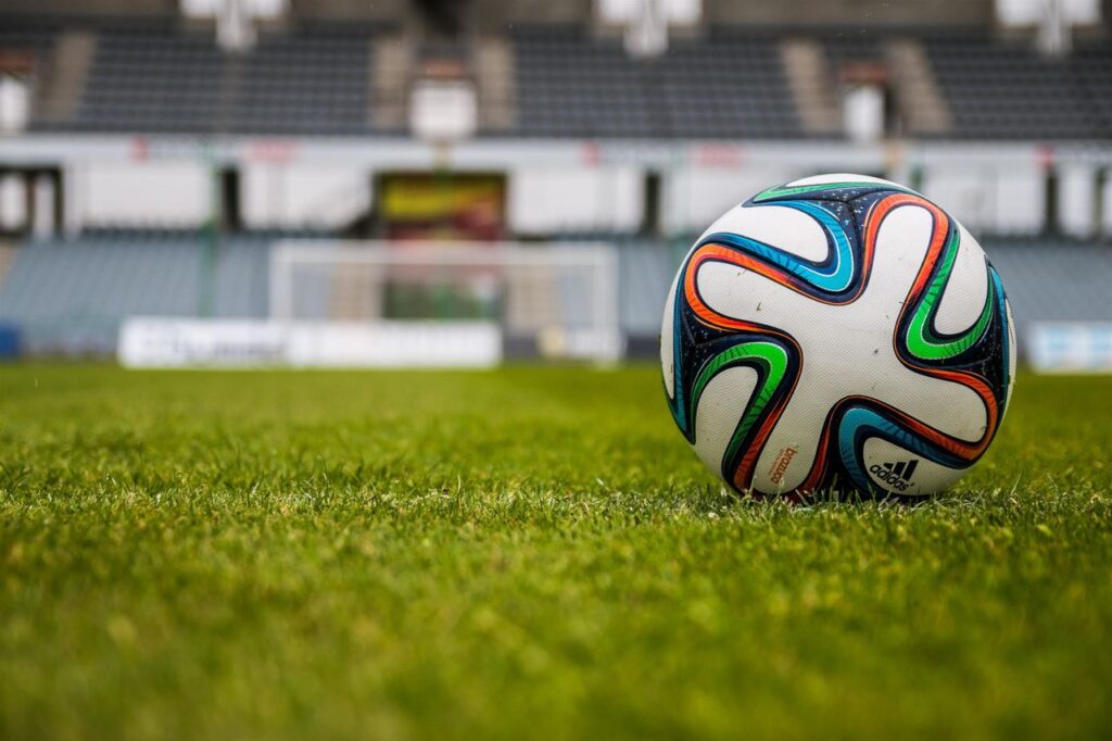 the ball stadion football the pitch 47354 Vibrant soccer ball on a lush green field in an empty stadium.