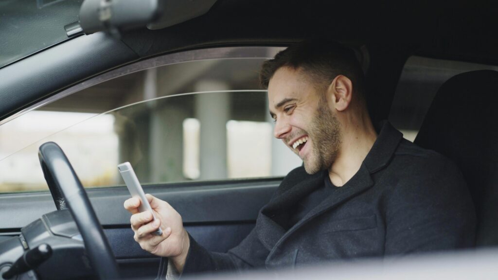 pexels photo 36812486 36812486 Young man enjoying a moment with his smartphone inside a car.